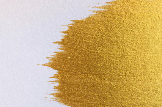Gold acrylic paint on white paper background , gold texture free