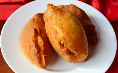Hot pies with fruit on a white plate.