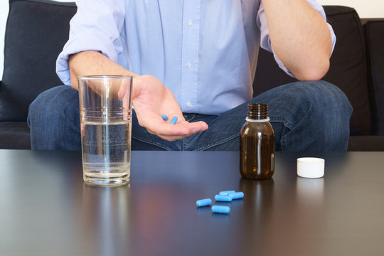 Man taking pills alone in room
