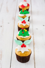 Christmas cupcakes on white wooden table background

