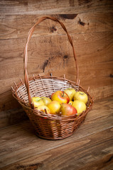 Basket with apples on wooden background