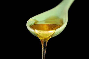 Honey flow down from a ceramic spoon