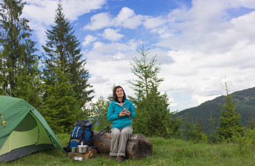 Fototapeta na wymiar Girl in hike with a tent in the mountains in summer