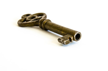 Antique brass skeleton key angled in on white background