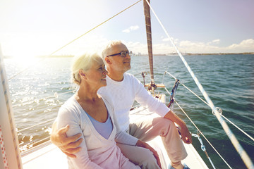 senior couple hugging on sail boat or yacht in sea