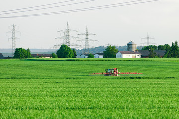 Fototapeta na wymiar Traktor beim Ausbringen von Pflanzenschutzmittel
