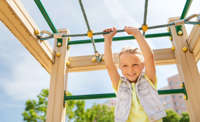 happy little girl climbing on children playground