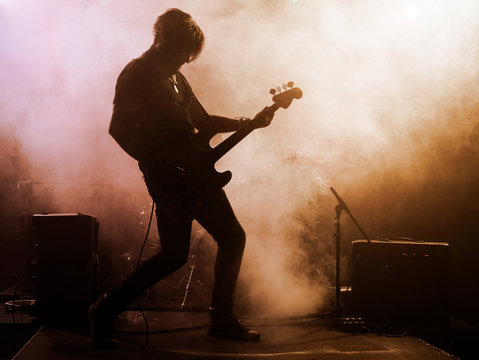 Rock band performs on stage. Guitarist.