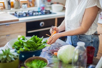 Woman cooking in kitchen with ingredients around her