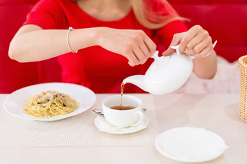 Pretty blonde young woman eating in restaurant.