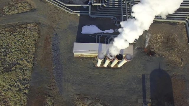 Aerial view of a geothermal power plant in Iceland. Steam rising upp against the sunlit sky from the plant