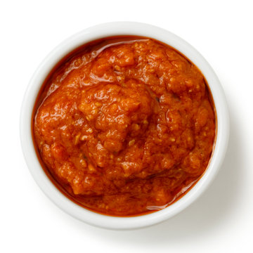 Bowl of traditional Italian red pesto isolated on white.