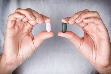 Woman holding colored pills in her hands