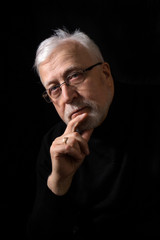 classic portrait of a beautiful elderly man on a black background