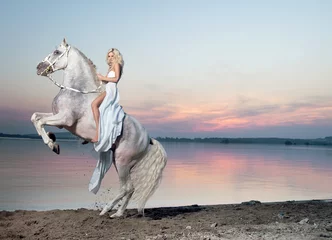 Foto op Aluminium Portrait of a blond woman riding a horse © konradbak