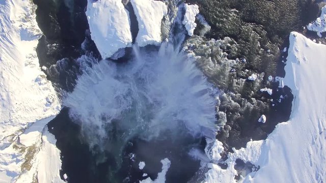 Aerial ultra high definition video of Godafoss waterfall in Iceland. Footage shot in winter with snow on the ground. Shoot with a DJI phantom pro. Drone travels downriver and over the waterfall itself