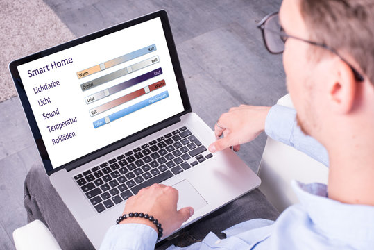 Junger Mann schaut auf Smart Home App auf seinem Computer