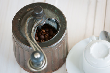 Coffee grinde and coffee beans on wooden desk