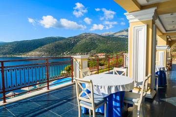 Table with chairs on terrace on coast of Kefalonia island in Agia Efimia village, Greece