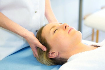 Obraz na płótnie Canvas Detail of a woman face receiving a relaxing facial massage
