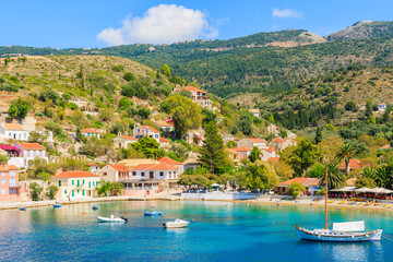 Fototapeta premium Colorful houses of Assos village and yacht boat in sea bay on Kefalonia island, Greece