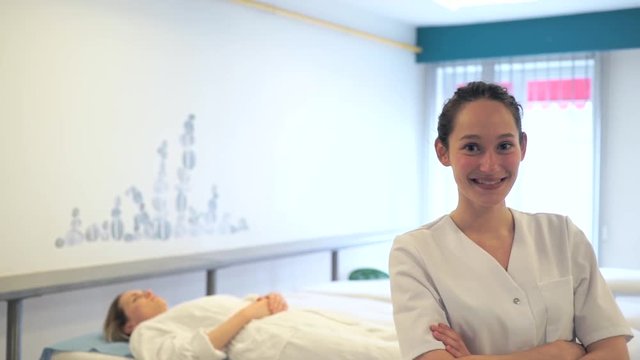 Portrait view of a young attractive masseuse in a professional room