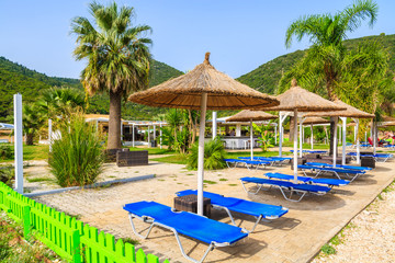 Sunbeds with umbrellas on famous Antisamos beach on Kefalonia island, Greece