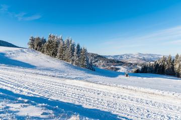 Winter road on sunny day in Beskid Sadecki Mountains, Poland