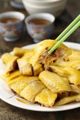 Plate of chopped steamed chicken on chopsticks