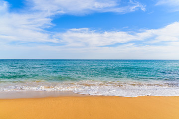 Ocean wave on sandy beach in Carvoeiro town