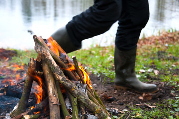 Obraz premium Man in waders by the campfire