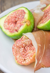 Figs and ham on white plate