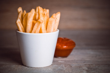 Toned photo. Color tone tuned. French fries on wooden background