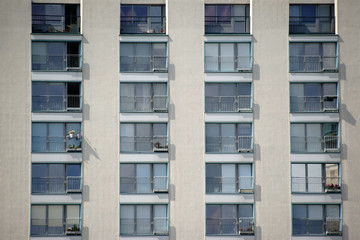 Wohngebäude / Ein mehrstöckiges Wohngebäude mit Reihenfenstern und Geländern.