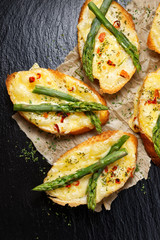 Cheese toasts with addition of asparagus and chili flakes, top view