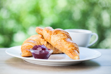 Tea and croissants on the natural background