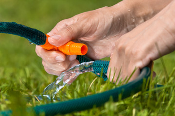 hands of gardener connecting hoses for irrigation, closeup