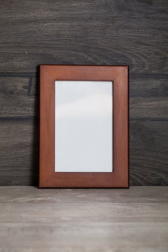 blank frame poster on the wooden table
