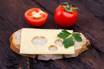 Bread, cheese, tomato and parsley on an old table