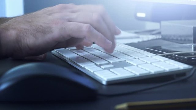 Hands typing computer keyboard