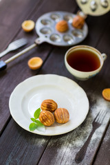 Walnut cookies on a white plate, wooden background