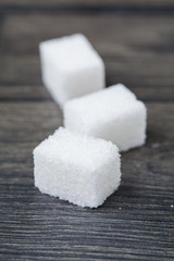 Cube of white sugar on black wooden background