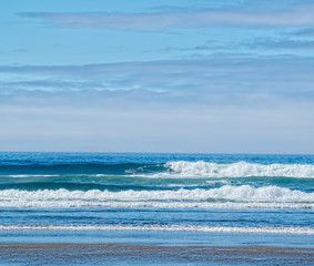 Cannon Beach waves and blue cloudy sky abstraction.  Oregon, USA.