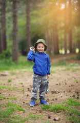 Young child boy in forest holding a lantern in his hand