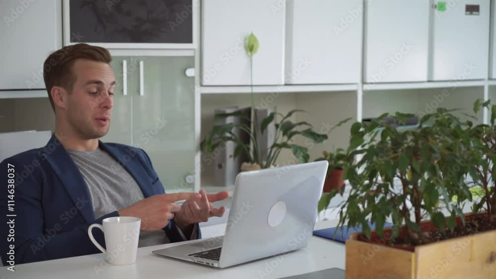 Poster young professional businessman has distant meeting via internet on computer. male call and emotional