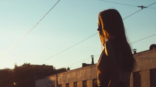 Portrait of young attractive thoughtful female at dusk. 60 FPS slow motion, 4K UHD RAW color graded footage