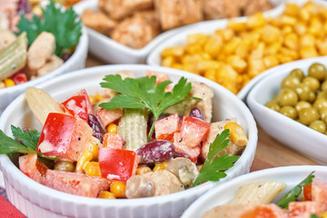 Chicken and vegetable salad in white bowls. Salad ingredients