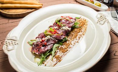 carpaccio with deer served on white plate