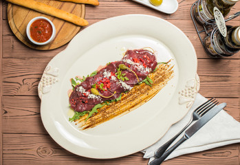 carpaccio with deer served on white plate
