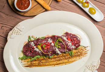 carpaccio with deer served on white plate